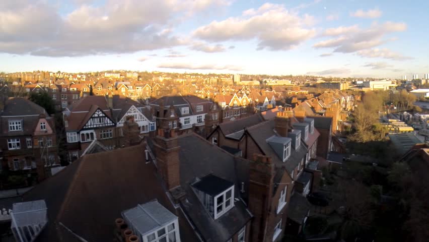 Flying above London surburban houses and apartments aerial view at dawn on sunny day