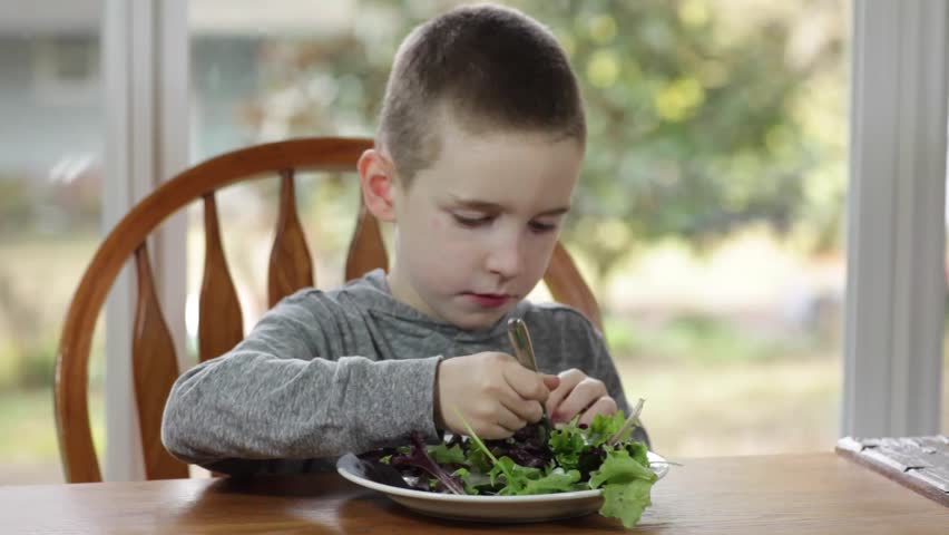 Boy eating a salad. 
