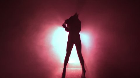 Slow-motion of a sensual girl dancing against red light