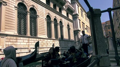 VENICE, ITALY - SEPTEMBER 1: The gondoliers chat while there gondolas pass by each other in Venice on September 1, 2012. Canals near San Marco square are usually full of gondolas with tourists.