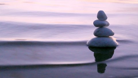 Stack of round smooth marble stones in Zen style and sea waves background