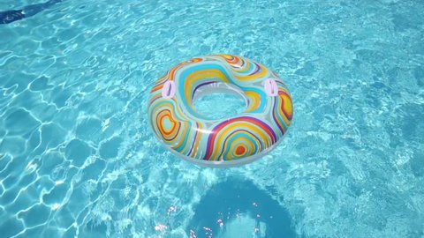 The boy jumped into the pool through inflatable circle