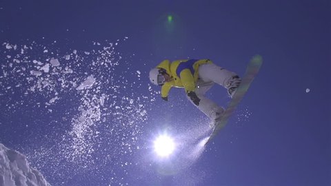 SLOW MOTION: Snowboarder jumps the kicker