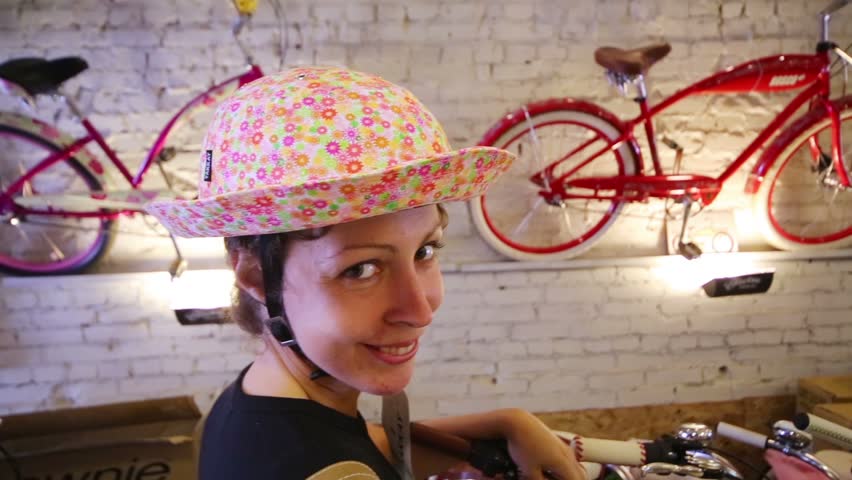 Happy beautiful woman i bikes with baskets in small shop