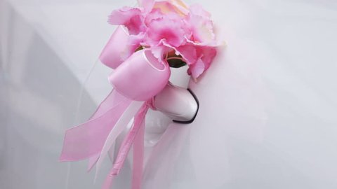 Pink decorative flower on a white car door handle
