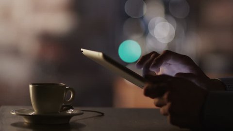 Man Using Tablet PC and Drinking Coffee in Cafe. Close-Up.Shot on RED Digital Cinema Camera in 4K(ultra-high definition (UHD)),so you can easily crop, rotate and zoom, without losing quality!