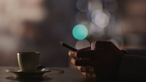 Man Typing a Message Using Mobile Phone at Evening Time in Coffee House.Close-Up. Shot on RED Digital Cinema Camera in 4K, ultra-high definition, UHD