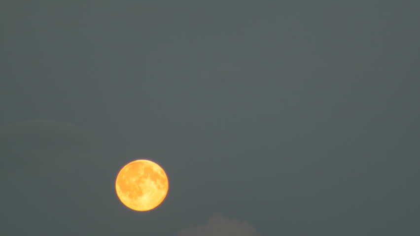 full moon moves across the sky in the clouds
