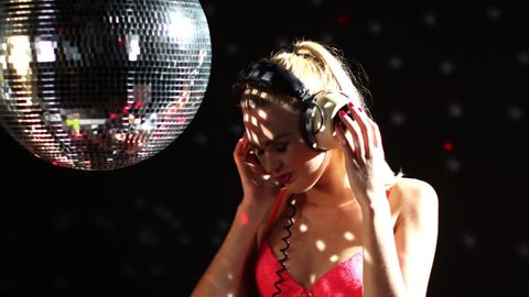 a sexy gogo dancer shot in a studio dancing and posing with a spinning disco ball. . this is a super high quality 4k version at 4096x2304 pixels
