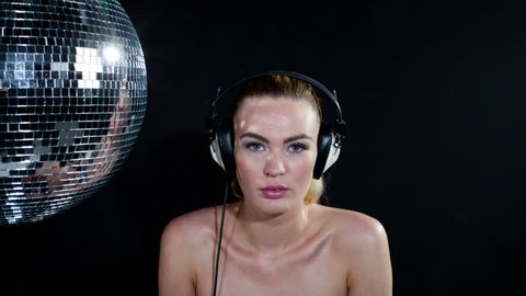 a sexy gogo dancer shot in a studio dancing and posing with a spinning disco ball. . this is a super high quality 4k version at 4096x2304 pixels