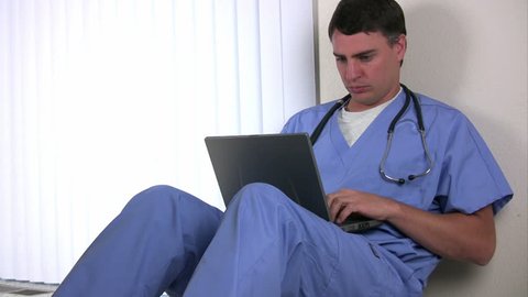 Doctor sitting and working on a laptop