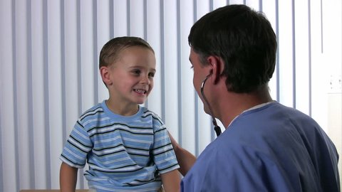 Happy boy listens to a male doctors lungs with a stethoscope