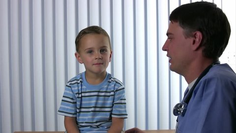 Medical person whispers in boys ear and he laughs hysterically