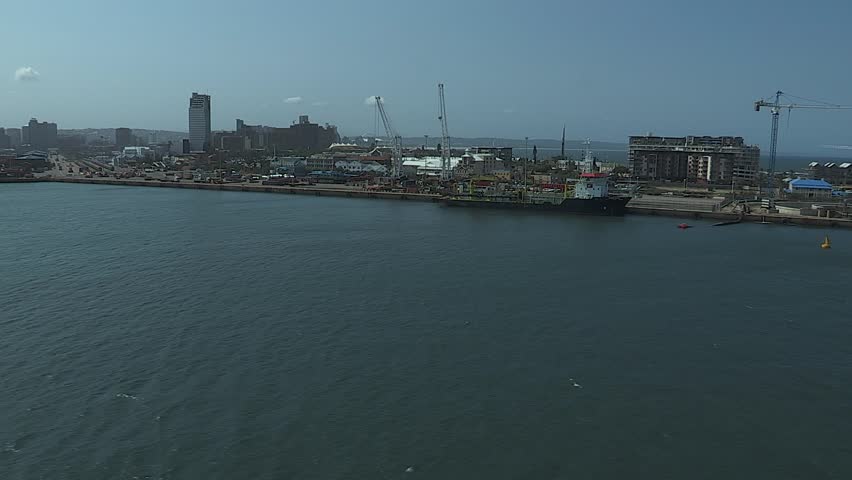 Durban harbour tracking shot with ship at the dock and city in the background.