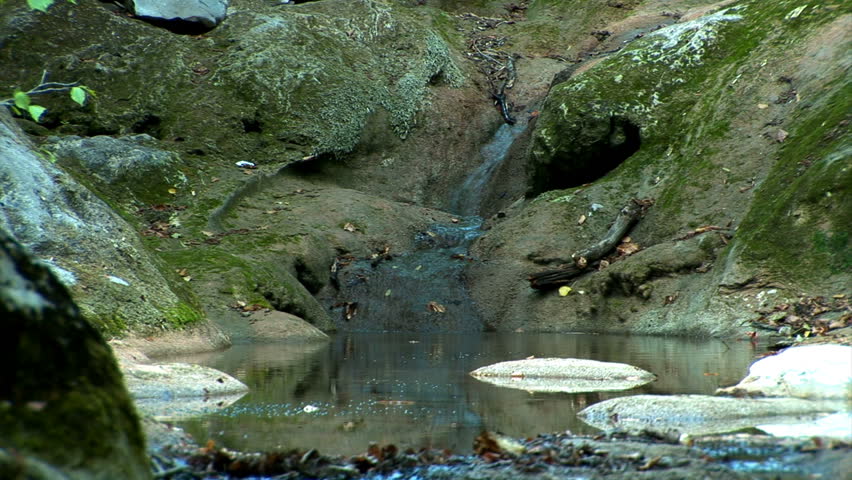 Rocks with moss. Between them stream.