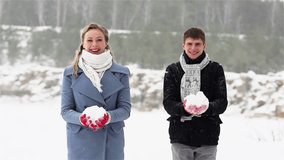 Slow-motion of ecstatic young people throwing snow up in the air and hugging