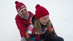 Slow-motion of cheerful friends riding a sled together