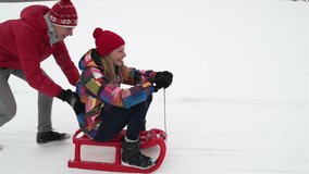 Slow-motion of playful friends having an active weekend sledding