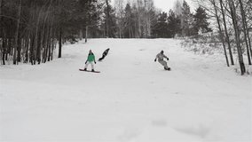 Slow-motion of group of snowboarders coming down the hill slope