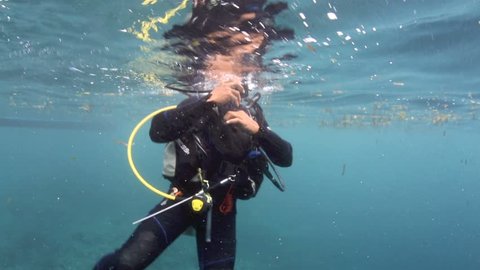 BUNAKEN ISLAND, SULAWESI, INDONESIA - DEC 28: Scuba diver commences dive and descends on December 28, 2013 in Bunaken Island, Sulawesi, Indonesia