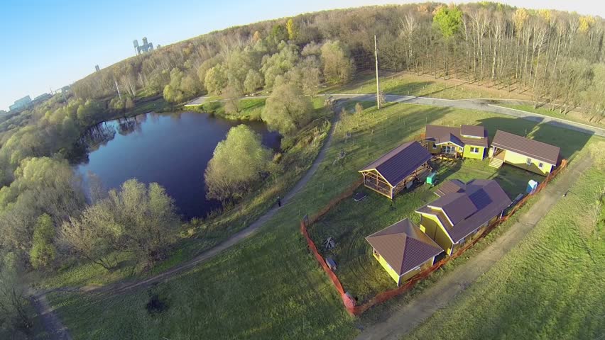 Group of few wooden houses with tiled roofs near pong at sunny autumn day on Elk Island