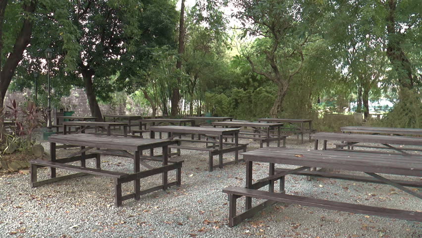peaceful picnic place on park with empty tables and chairs.
