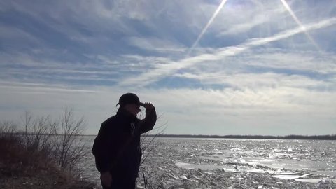Man Watching birds and eagles on the Mississippi River in Illinois on a January day.