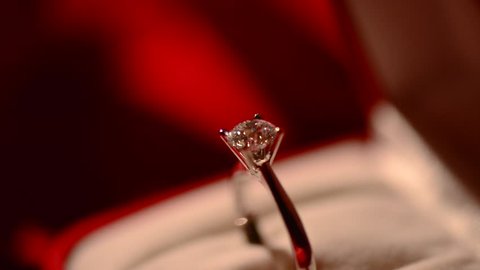 Diamond ring. Valentine's Day Gift. Marriage Proposal. Beautiful Ring - white gold with big diamond (one carat) on red silk background. Rotation
