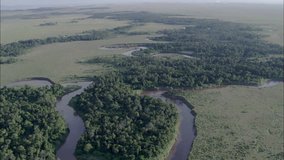 sky water forest. This clip is a birds eye view of the land below. It is a slow pan of the land, water, and forest