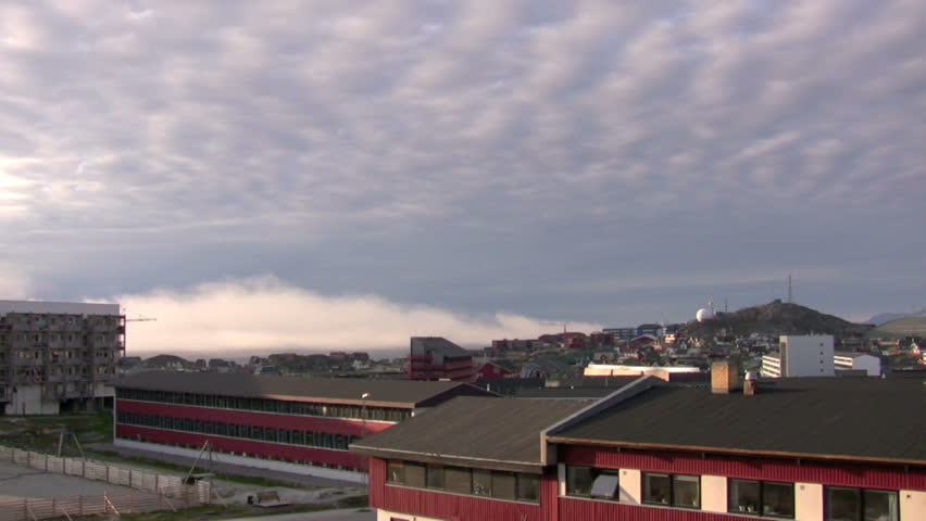 Time lapse shot of the sky moving above and the fog rolling in over the city of Nuuk, Greenland.