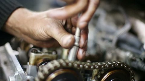 Mechanic hands unscrews screw by screwdriver of gasoline car motor