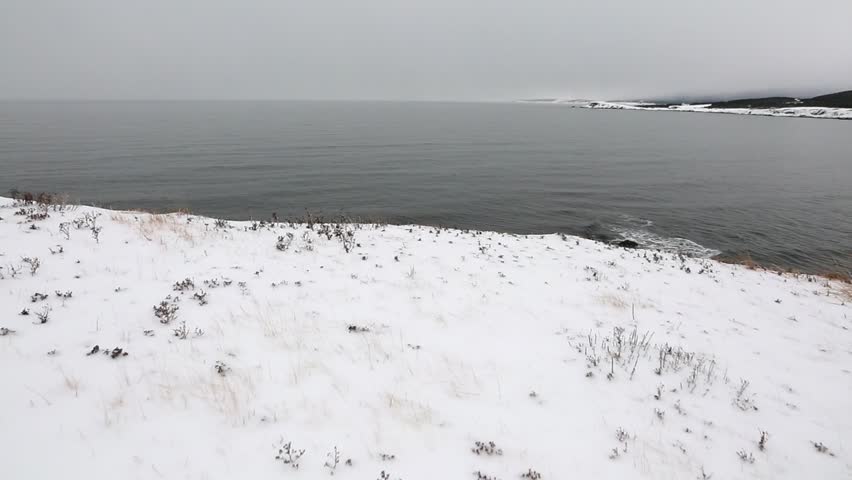 A steadicam shot of a cold winter beach covered in ice