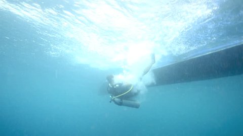 Underwater view of scuba diver backward roll entry into ocean from dive boat in Bunaken National Park, north Sulawesi