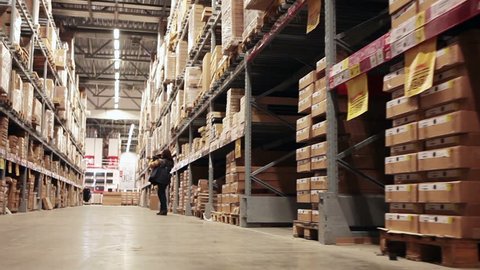Buyer standing at big wholesale shop warehouse and choosing goods