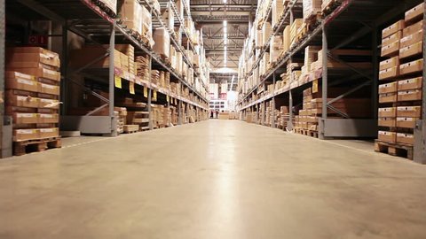 Camera moving between palettes with ordered goods and materials at warehouse