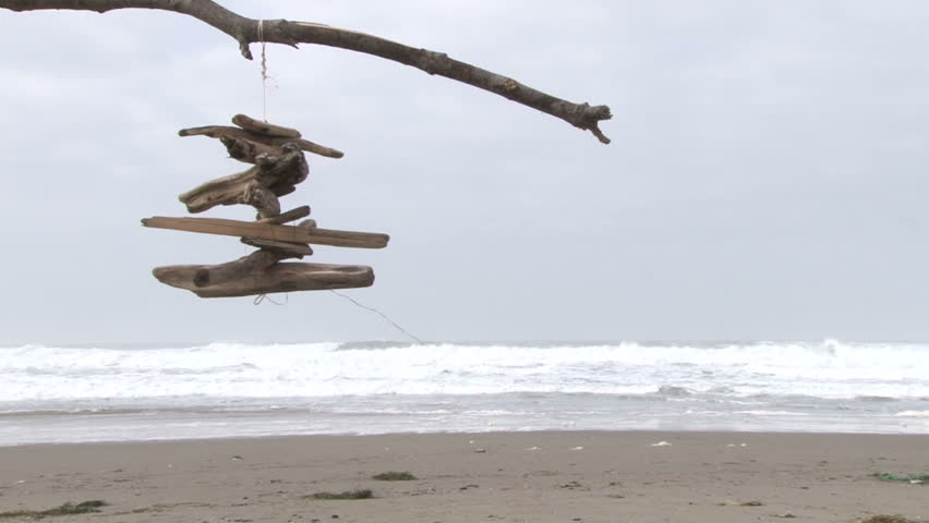 Crafty driftwood weathervane spinning on windy day at the Oregon Coast, Pacific Ocean.