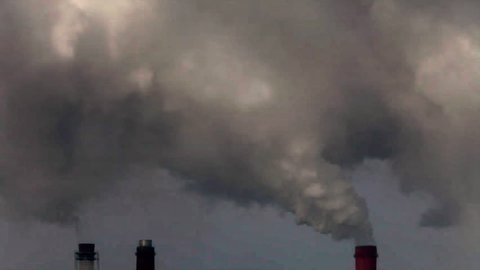 Dramatic view of of three smoke or steam stacks with total smog above. Dioxide carbon and warm, exhausting with the industry chimneys in the atmosphere, is the great danger for global ecology.
