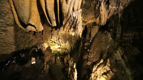 Descent into underground cave with stalactites and stalagmites
