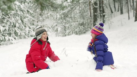 Slow-motion of joyful kids playing in snow fighting with each other