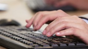 Close-up of an office worker typing fluently