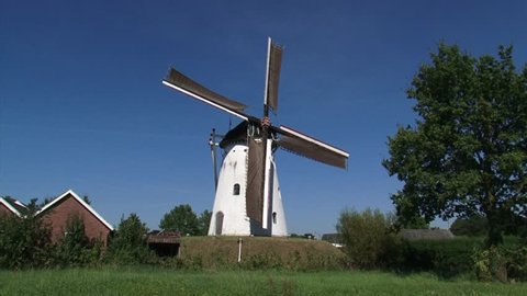 Dutch Beltmolen, a windmill which stands on and in an artificial mound. Parts of the mound are dug away to give access to the large loading doors in the base, ZEDDAM, THE NETHERLANDS 