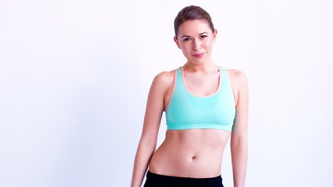 Happy and Relaxed Young Woman in Fitness Clothes Posing on White