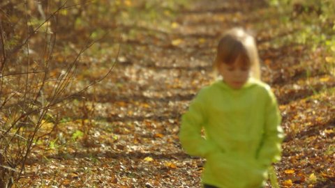 Stock Video Footage Little girl walks in autumn alley. Slow motion.