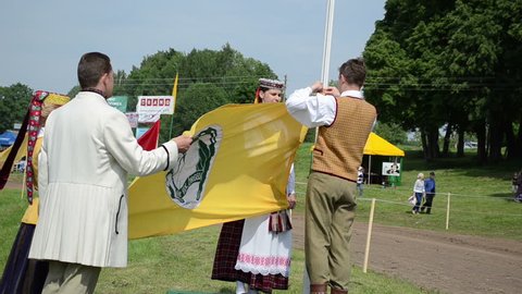 people with national costumes rise festival Run, Run Horse flag on June in Niuronys, Lithuania.