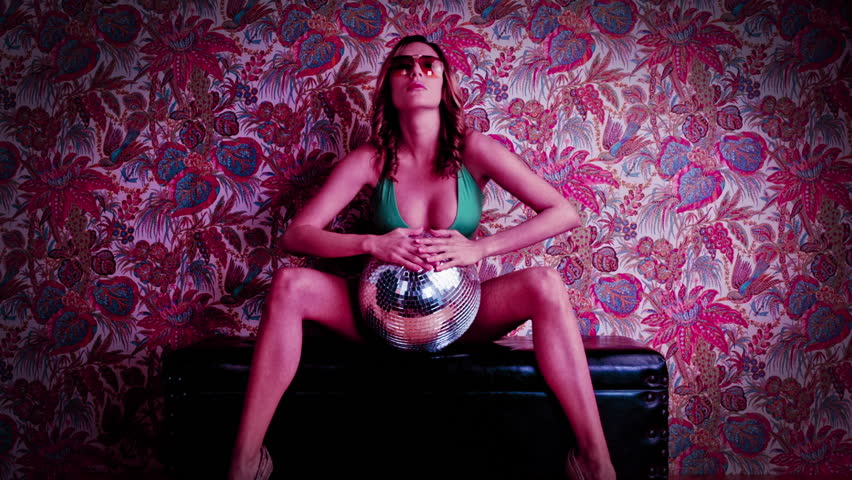 beautiful woman in green bikini poses and dances against a cool vintage flower wallpaper. good clip for party, celebration of music events
