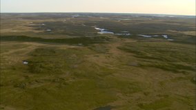Meandering river in tundra. A vast tundra and grassland with a snaking river cutting though the landscape.