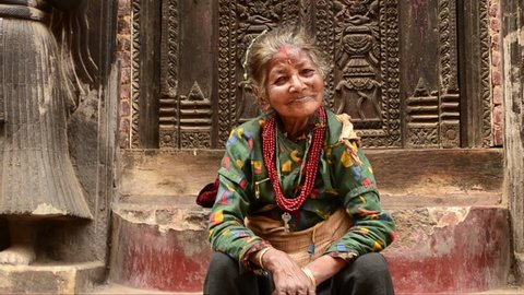 Nepal. Kathmandu. Happy woman sits near the entrance of the temple
