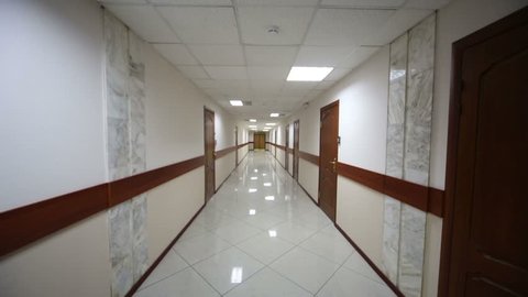 Switching on lights in hallway with brown doors and white floor