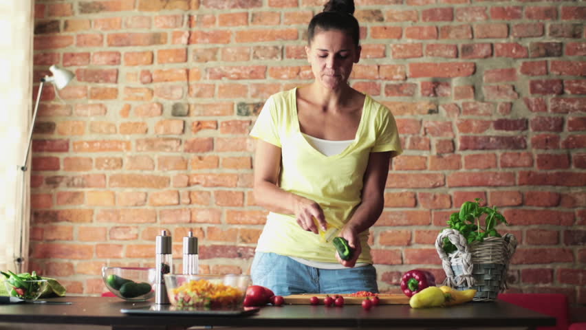 Young woman peel fresh cucumber
