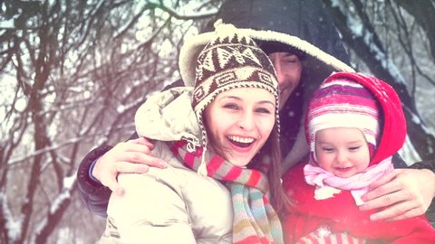 Beautiful Winter Family having fun outdoors. Happy laughing father, mother with their little baby girl playing in Winter park. Mom and Dad with a child. Snow. Slow motion 240fps. Slowmo 1080p
